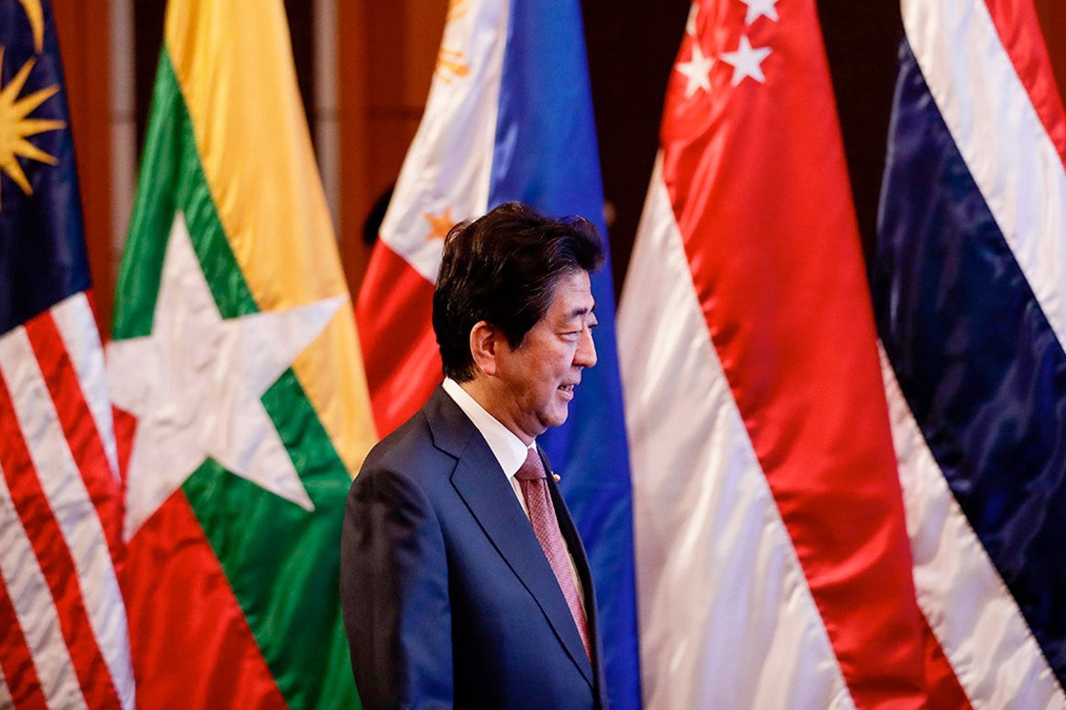 Shinzo Abe in front of flags